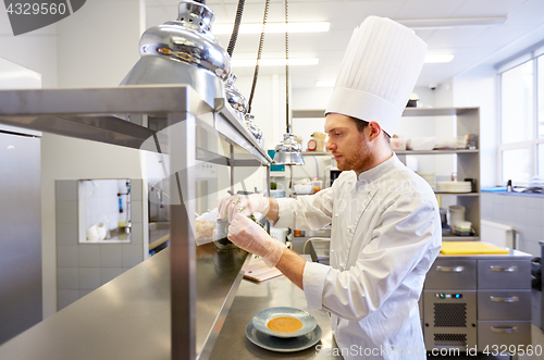 Image of happy male chef cooking at restaurant kitchen