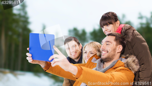 Image of friends with tablet pc taking selfie in winter