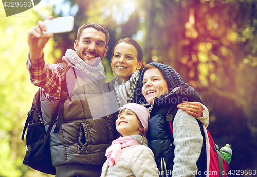 Image of family taking selfie with smartphone in woods