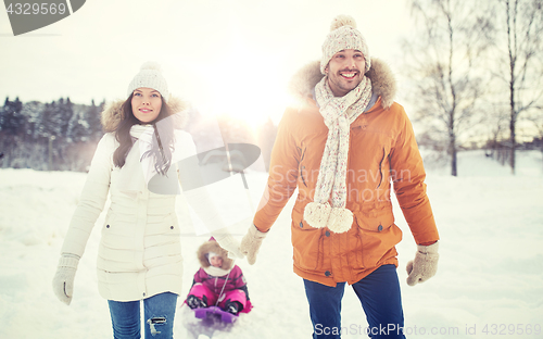 Image of happy family with sled walking in winter outdoors