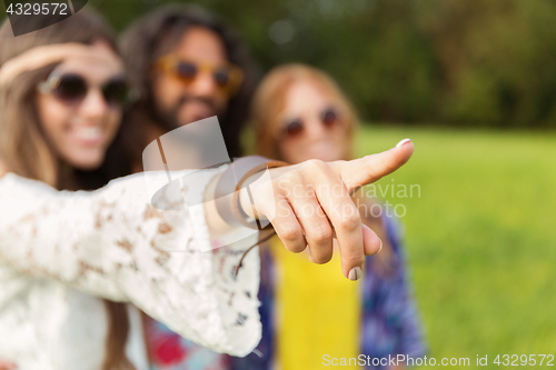 Image of happy hippie woman pointing finger outdoors