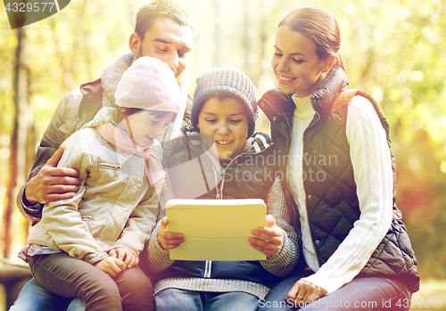Image of family sitting on bench with tablet pc at camp
