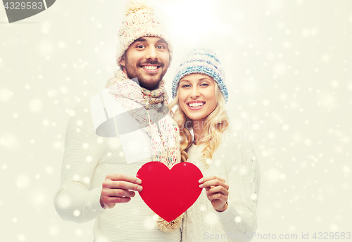 Image of smiling couple in winter clothes with red heart