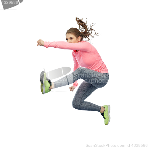 Image of happy sporty young woman jumping in fighting pose