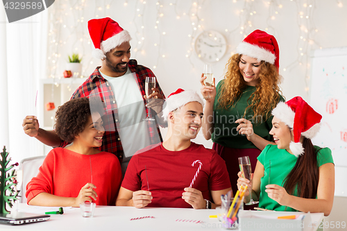 Image of happy team celebrating christmas at office party