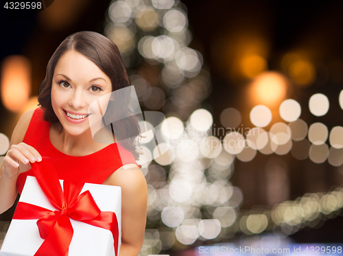 Image of smiling woman in red dress with christmas gift box
