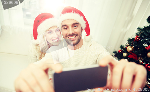 Image of couple taking selfie with smartphone at christmas