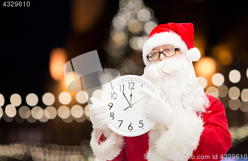 Image of santa claus with clock pointing finger to twelve