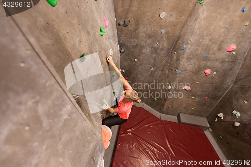 Image of young woman exercising at indoor climbing gym