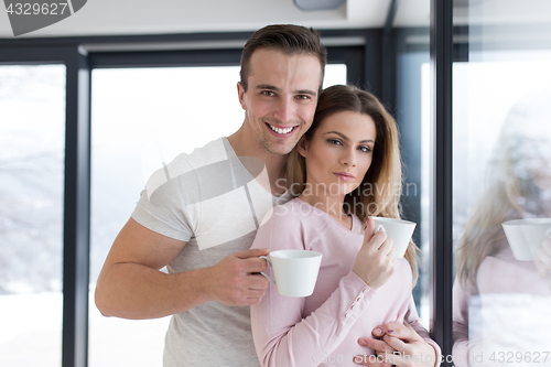 Image of young couple enjoying morning coffee by the window