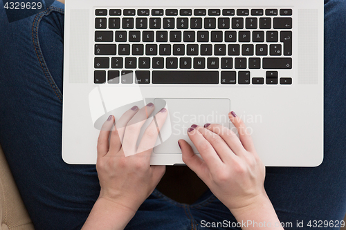 Image of young woman on sofa at home websurfing