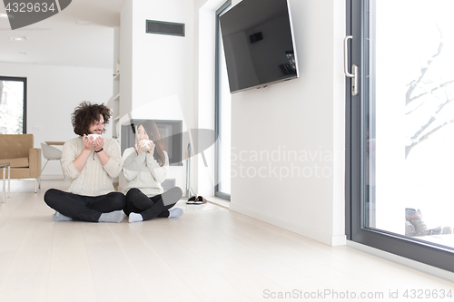 Image of happy multiethnic couple  in front of fireplace