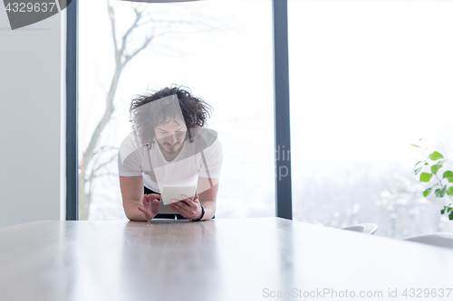 Image of young man using a tablet at home