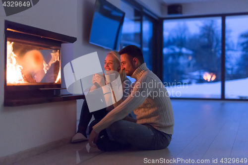 Image of happy couple in front of fireplace