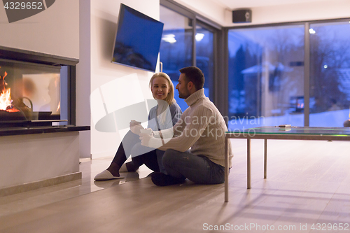 Image of happy couple in front of fireplace