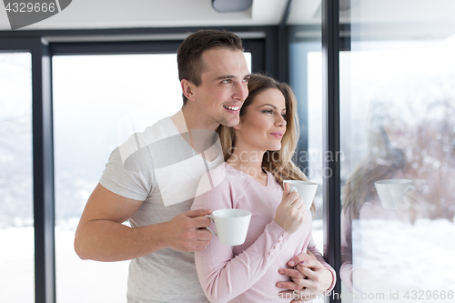 Image of young couple enjoying morning coffee by the window