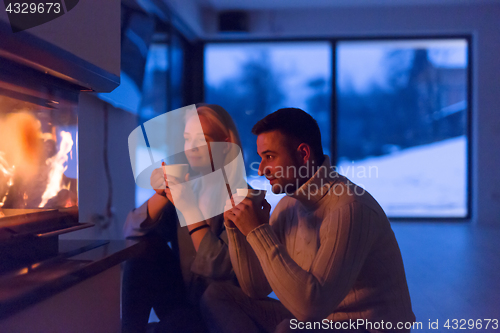 Image of happy couple in front of fireplace