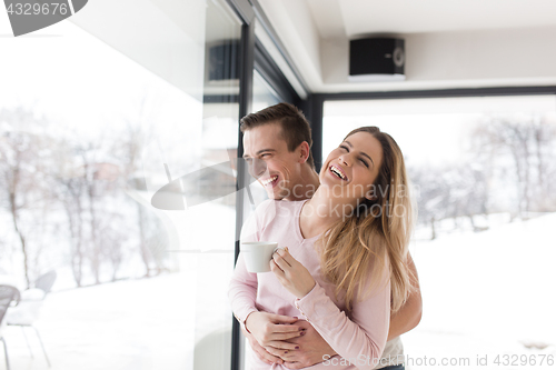 Image of young couple enjoying morning coffee by the window