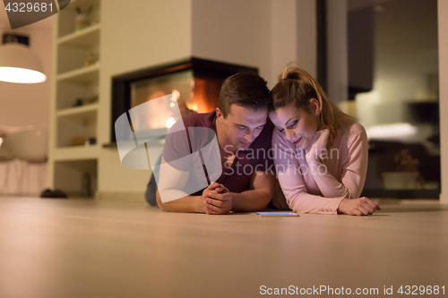 Image of Young Couple using digital tablet on cold winter night