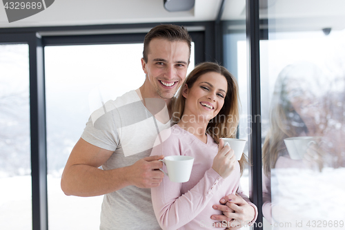 Image of young couple enjoying morning coffee by the window