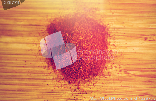 Image of cayenne pepper or paprika powder on wood