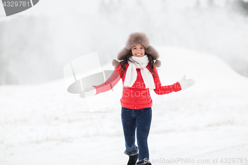 Image of happy woman in winter fur hat outdoors