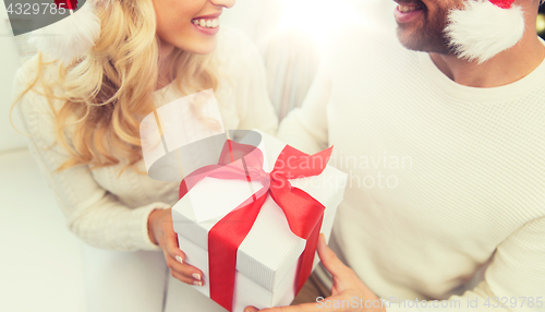 Image of close up of couple with christmas gift at home