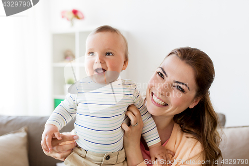 Image of happy young mother with little baby at home