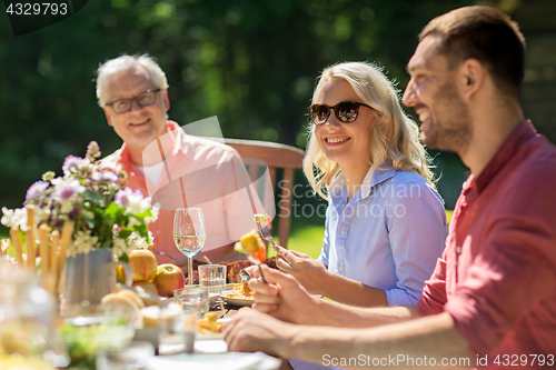 Image of happy family having dinner or summer garden party
