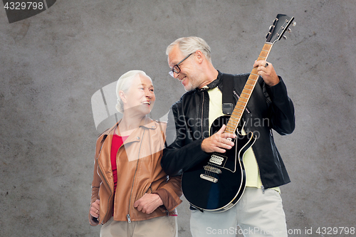 Image of happy senior couple with electric guitar