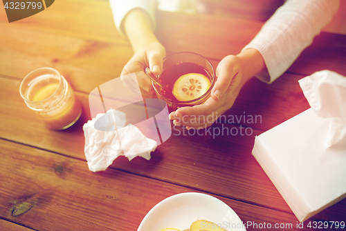 Image of close up of ill woman drinking tea with lemon