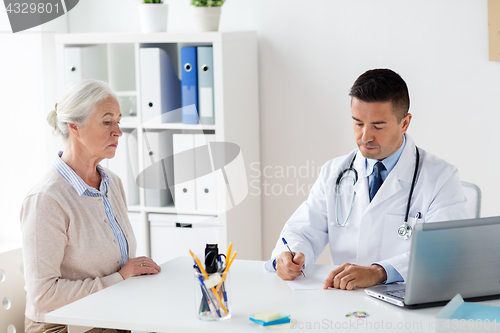 Image of woman and doctor with prescription at clinic