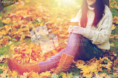 Image of close up of woman drinking coffee in autumn park