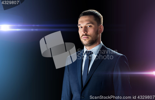 Image of businessman in suit over black