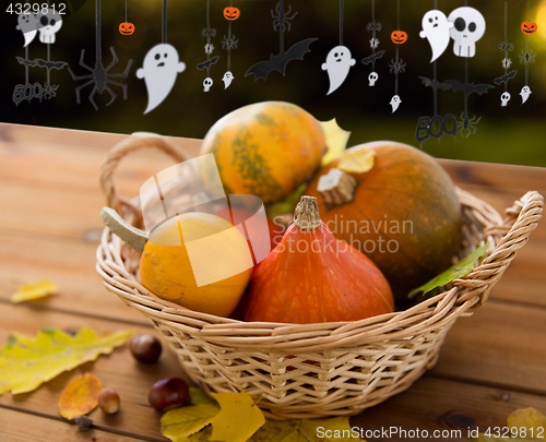 Image of pumpkins in basket and halloween party garland