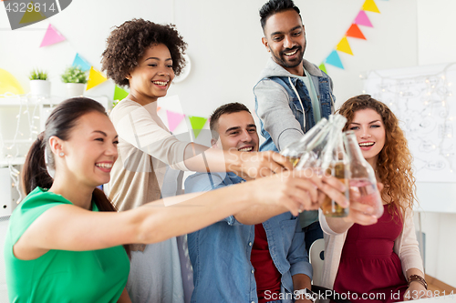 Image of happy team with drinks celebrating at office party