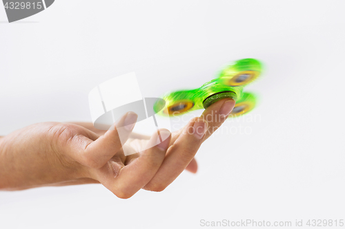 Image of close up of hand playing with fidget spinner