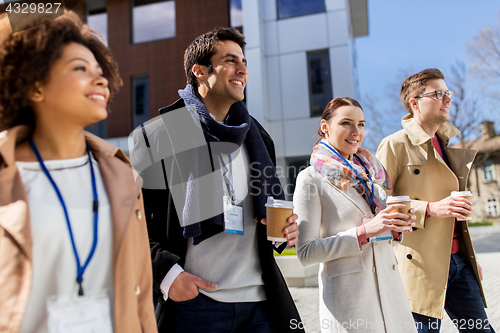 Image of people with coffee and conference badges in city