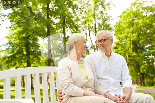 Image of happy senior couple hugging in city park