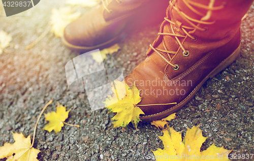 Image of female feet in boots and autumn leaves