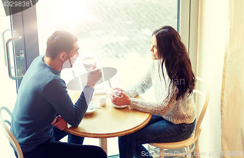 Image of happy couple drinking tea and coffee at cafe