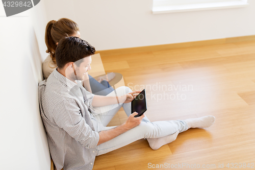 Image of happy couple with tablet pc computer at new home