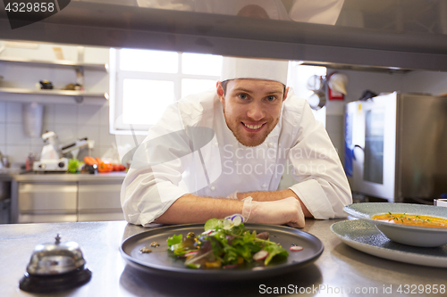 Image of happy male chef cooking food at restaurant kitchen