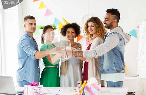 Image of happy team with champagne at office birthday party