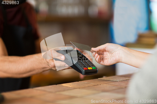 Image of hands with payment terminal and credit card