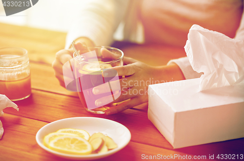 Image of close up of ill woman drinking tea with lemon