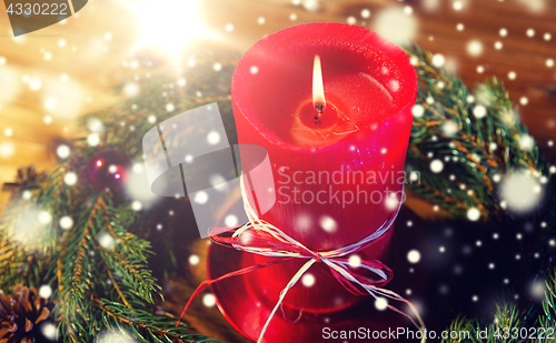 Image of fir branch wreath with candle on wooden table