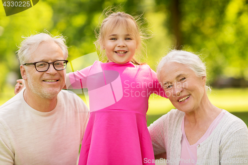 Image of senior grandparents and granddaughter at park