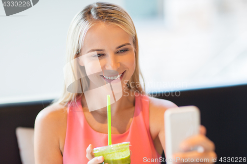 Image of woman with smartphone taking selfie at restaurant