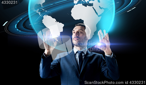 Image of businessman with earth hologram over black